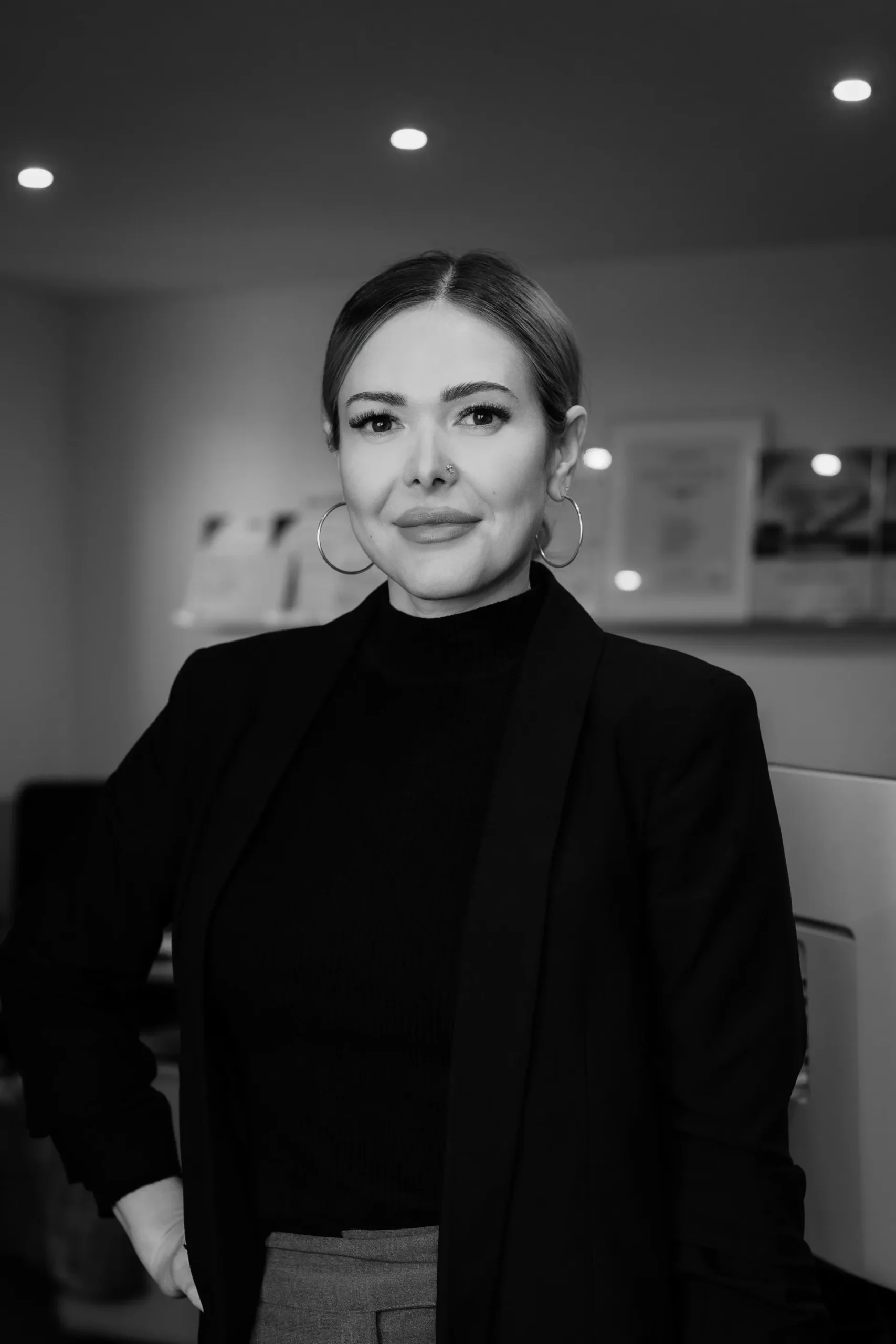 Porträt einer Mitarbeiterin im dunklen Oberteil.